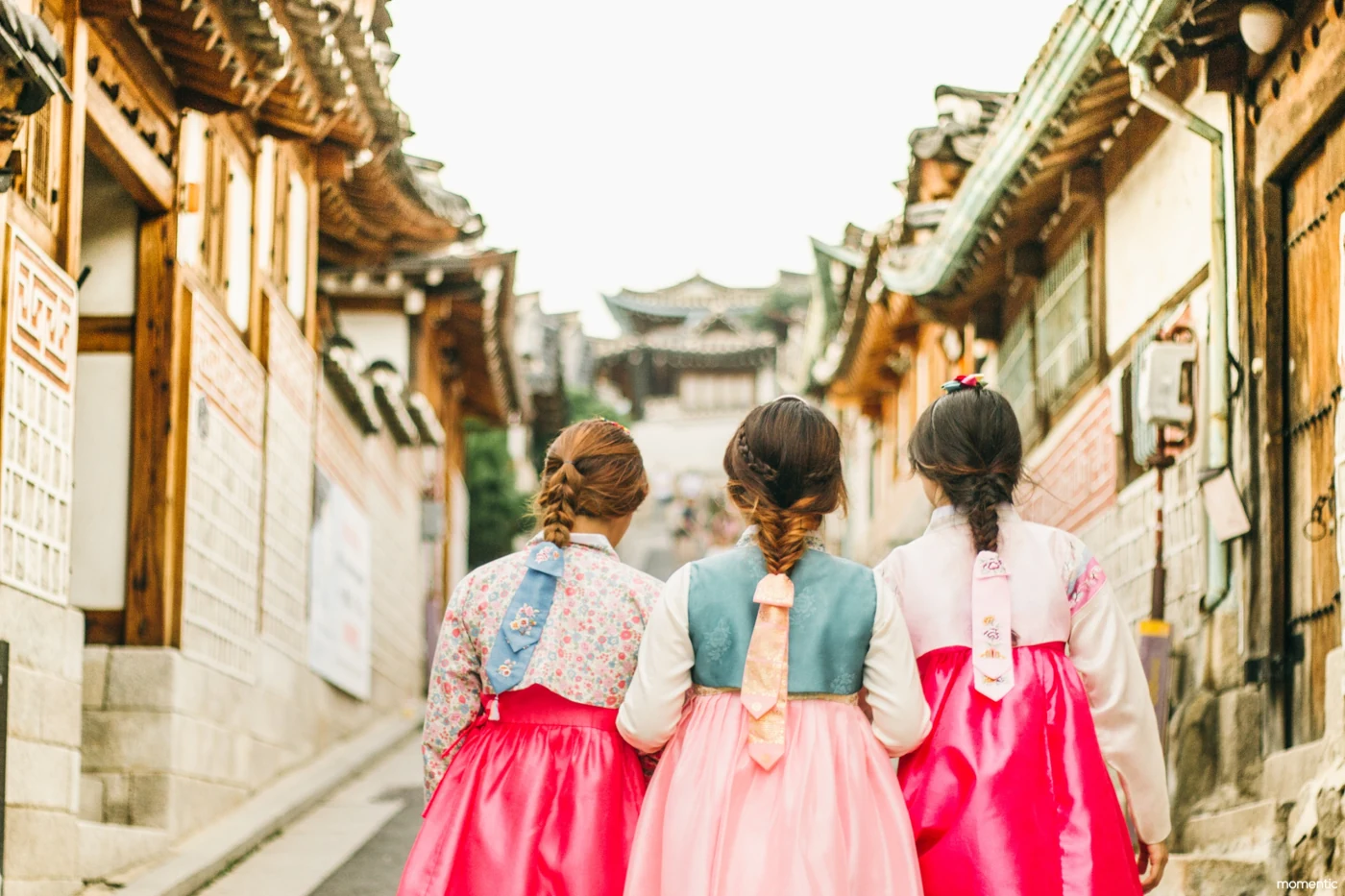 한복을 입고 북촌한옥마을 골목을 걷는 사람들