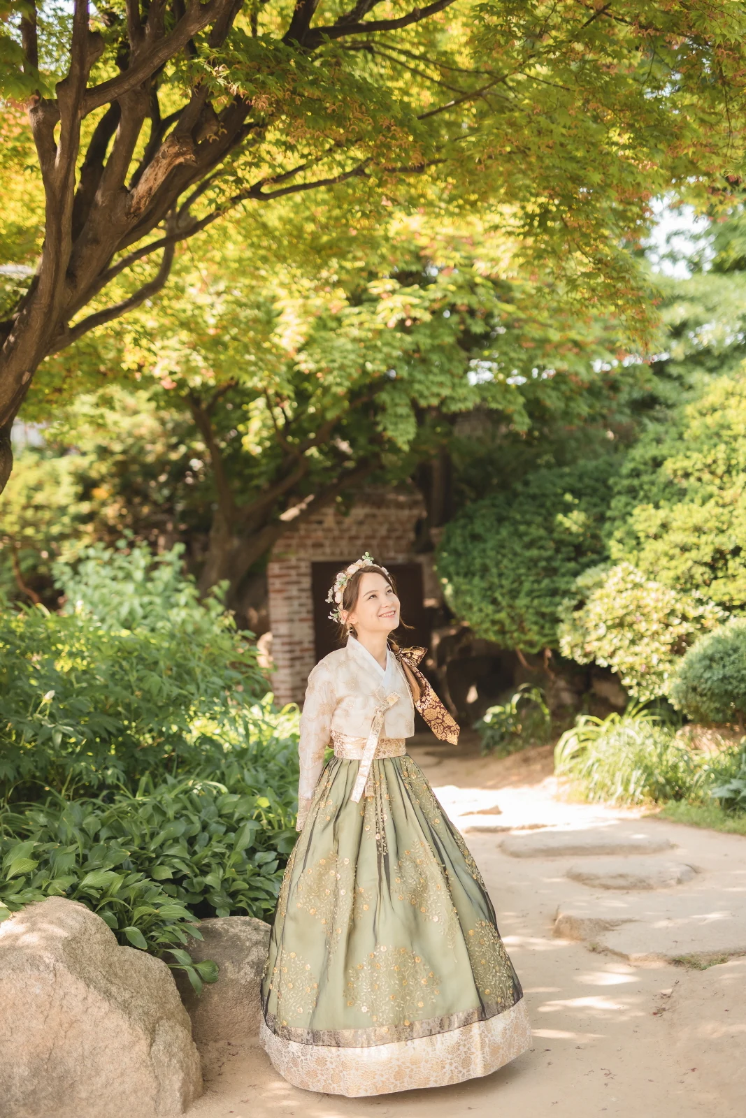 푸른 정원에서 연두색 한복을 입은 사람
