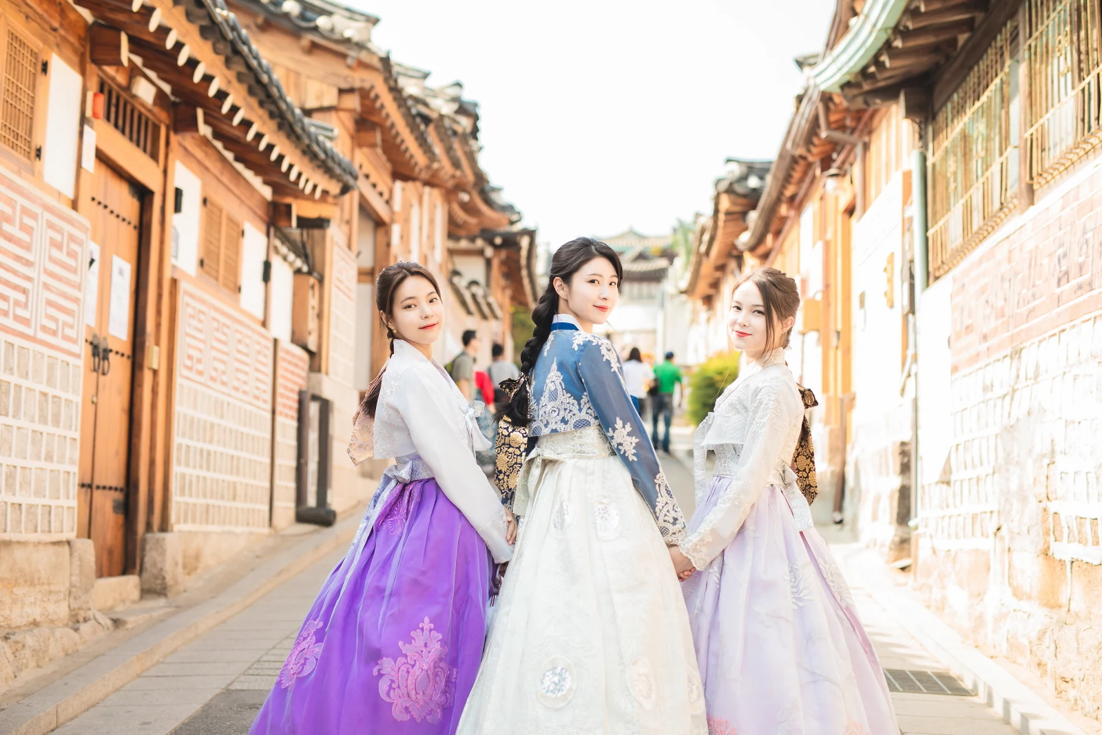 고운 한복을 입고 북촌 한옥 골목을 걷는 세 사람